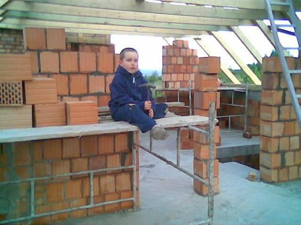 dziedzic na rusztowaniu z niedłącznym narzędziem do niszczenia gruzu